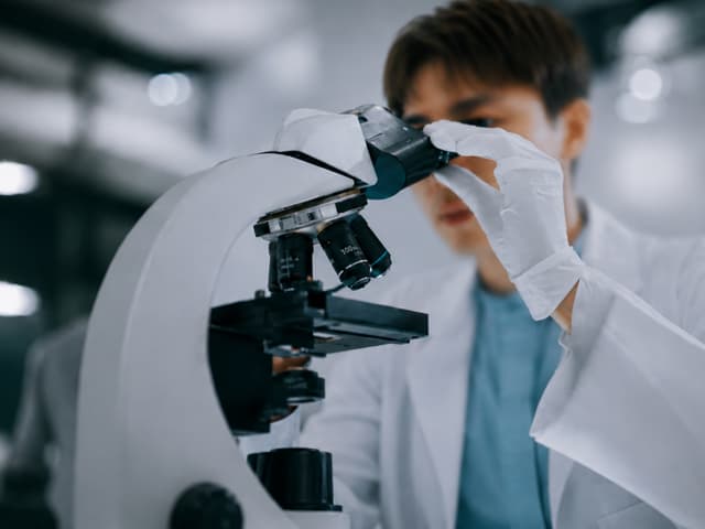 Researcher examining a sample under a microscope